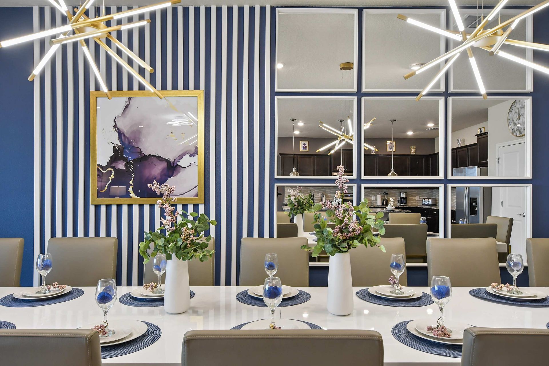 Elegant dining area with bold striped accent wall, modern lighting, and mirror décor