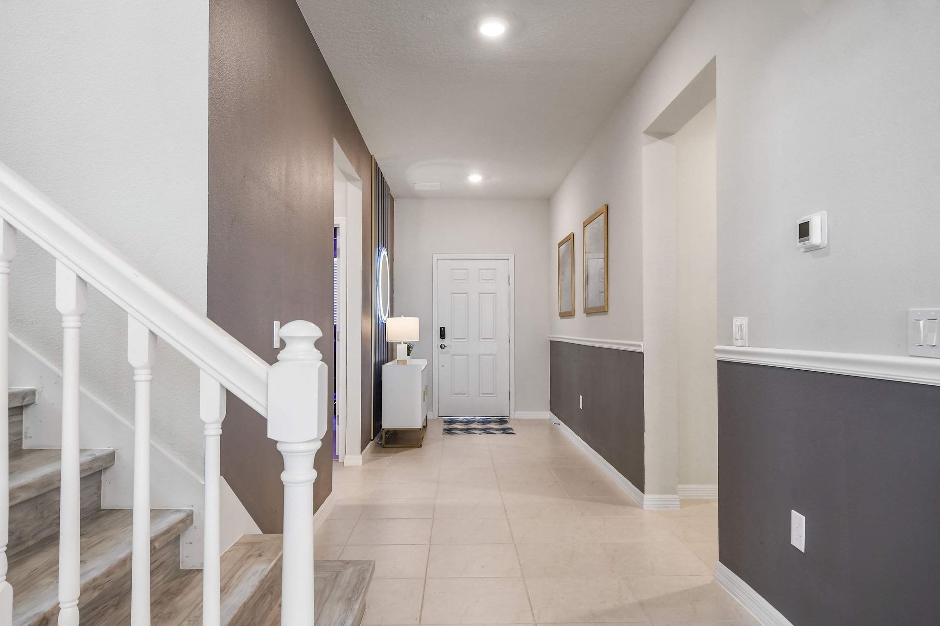 Welcoming entryway with modern décor, stylish lighting, and open access to living areas