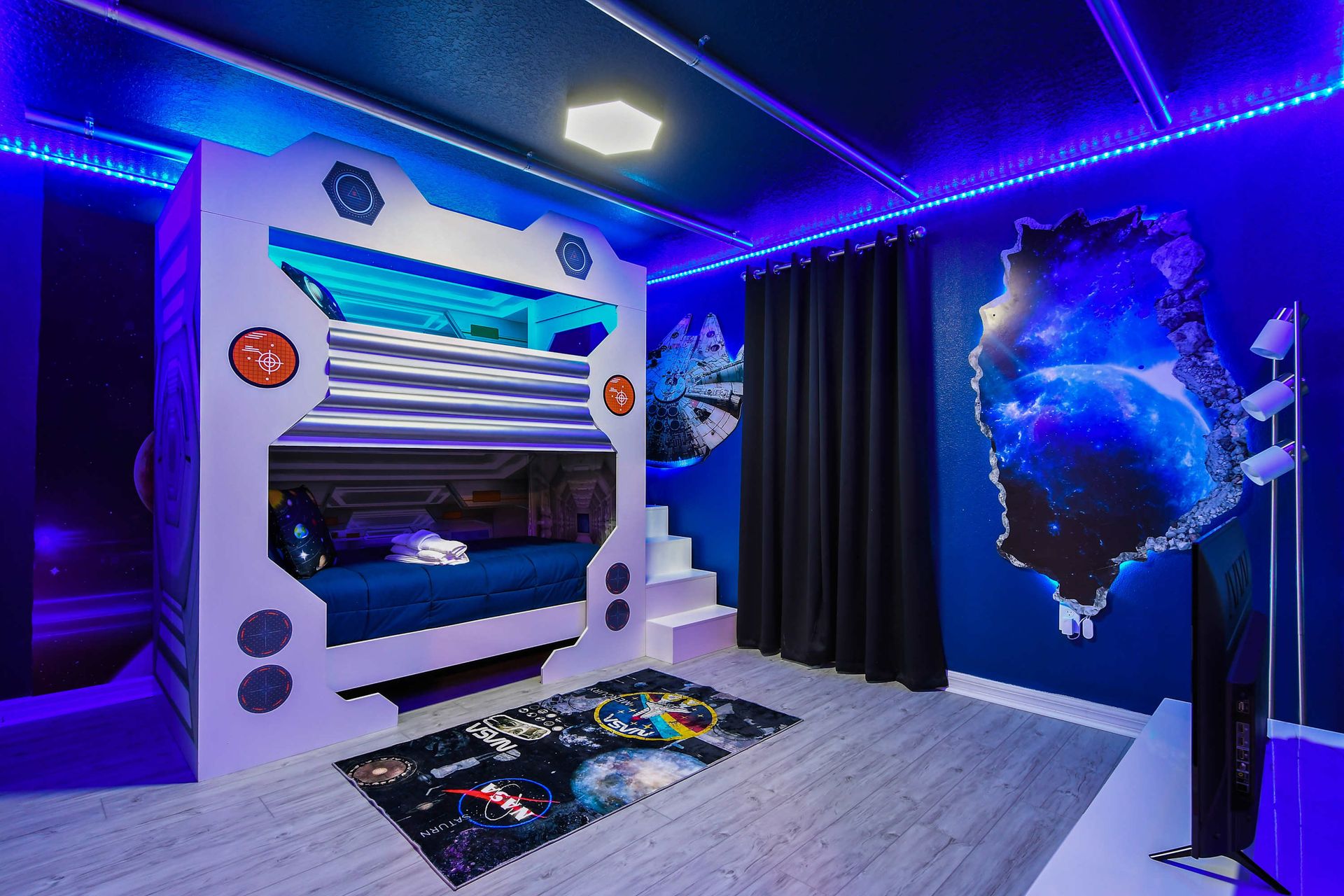 Futuristic space-themed bunk room with glowing lights and galactic wall art