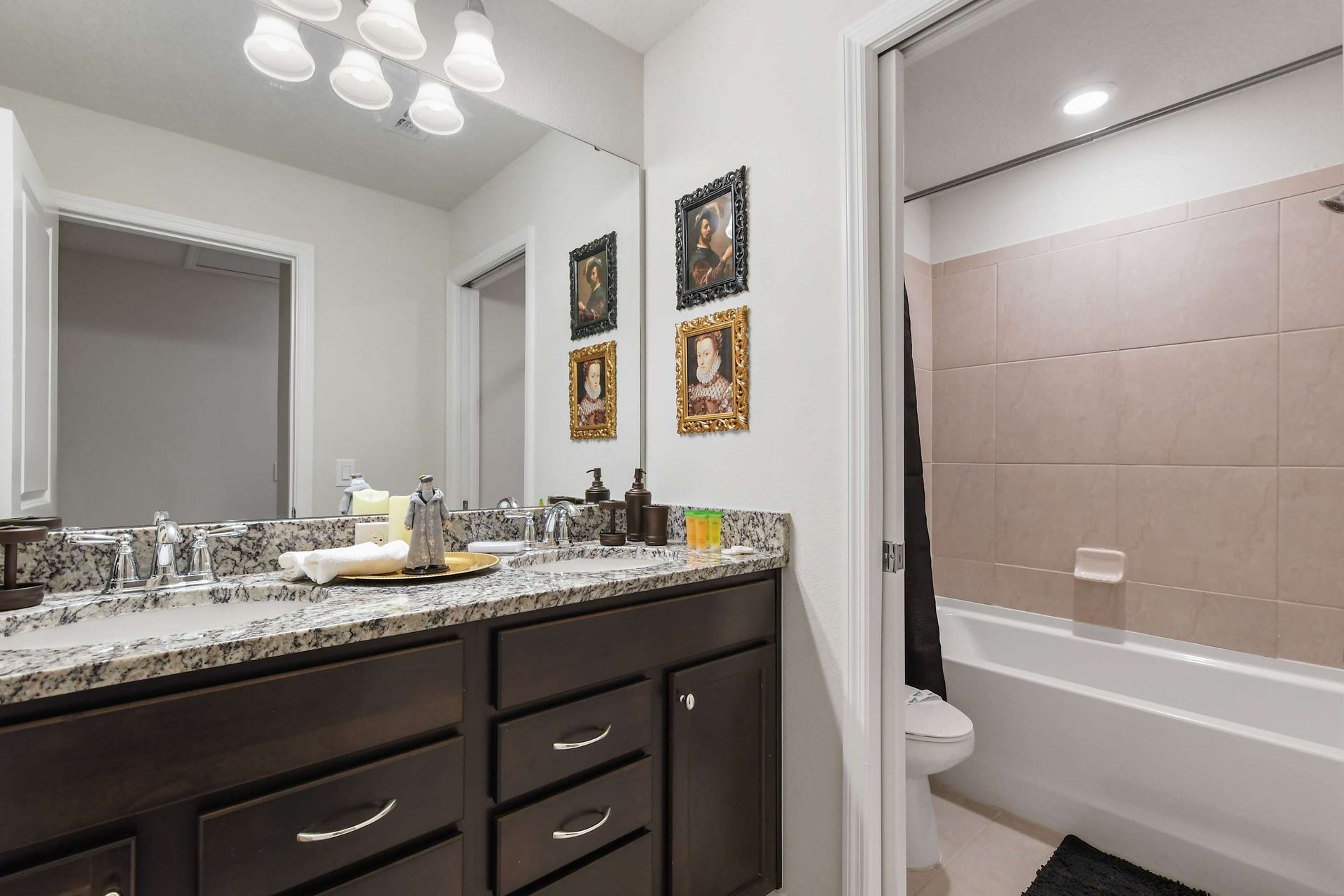 Bright and stylish bathroom featuring a granite countertop, dark wood cabinetry, and a sleek glass-enclosed shower. 
