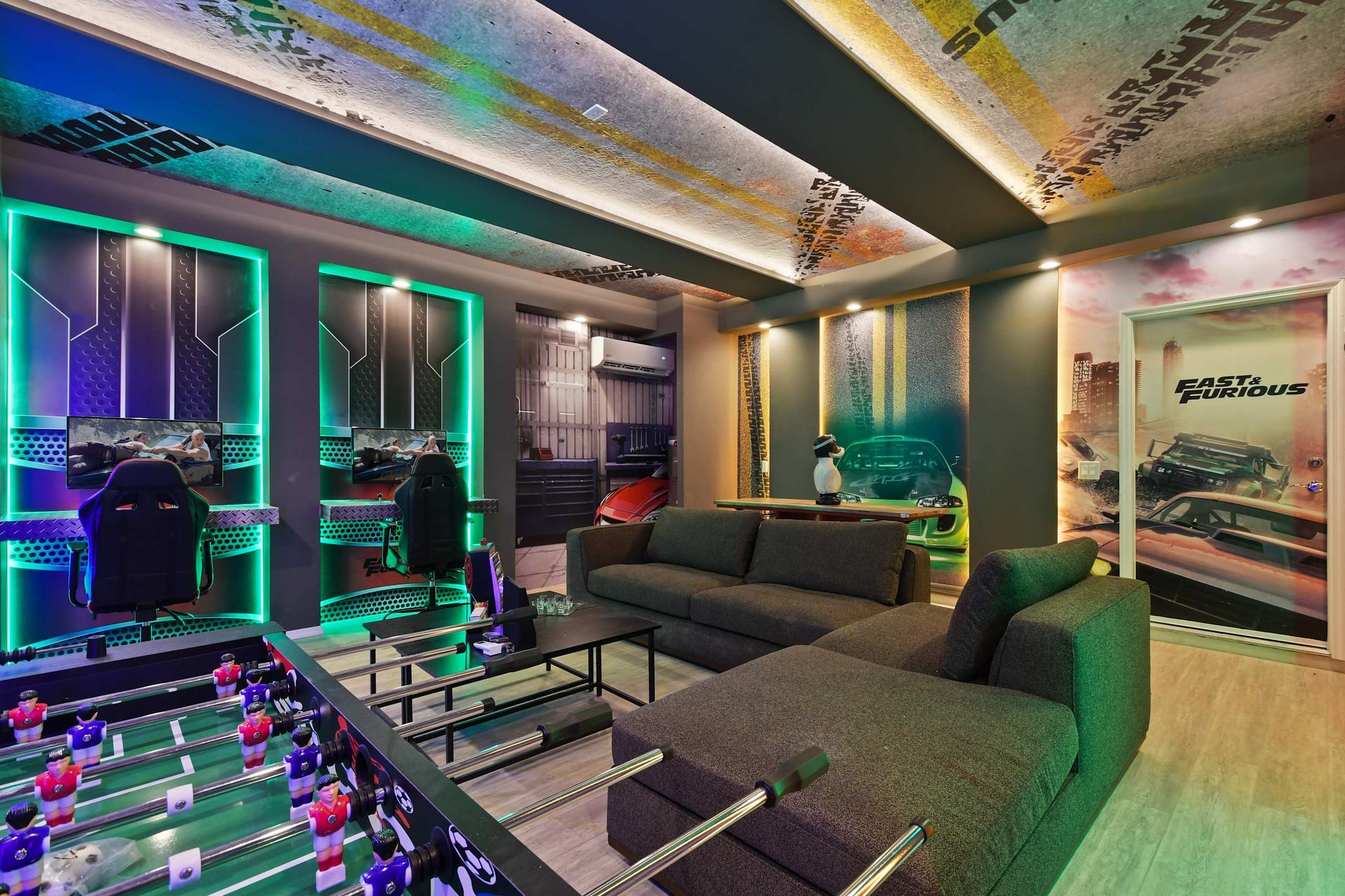 Fast & Furious-themed game room with racing simulators, foosball, and bold lighting.