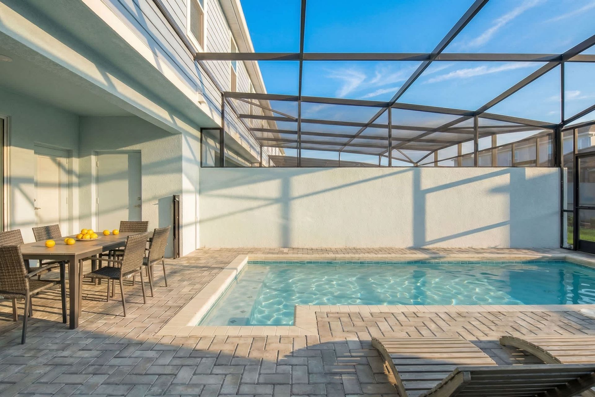 Relax in your private screened-in pool oasis with loungers and outdoor dining.