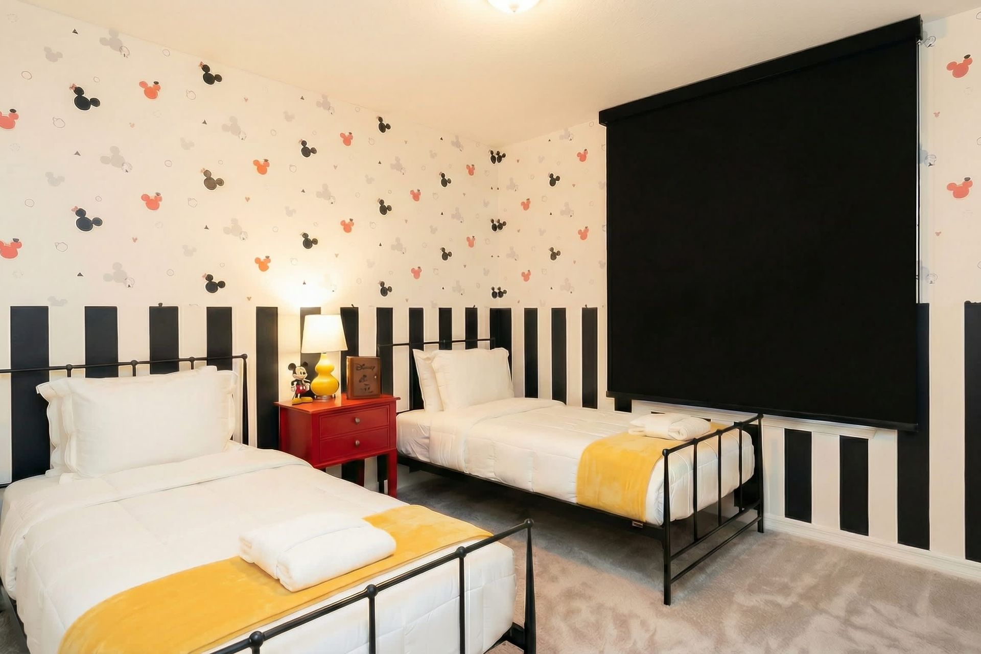 Playful twin room with bold stripes, fun decor, and cozy bedding for kids.