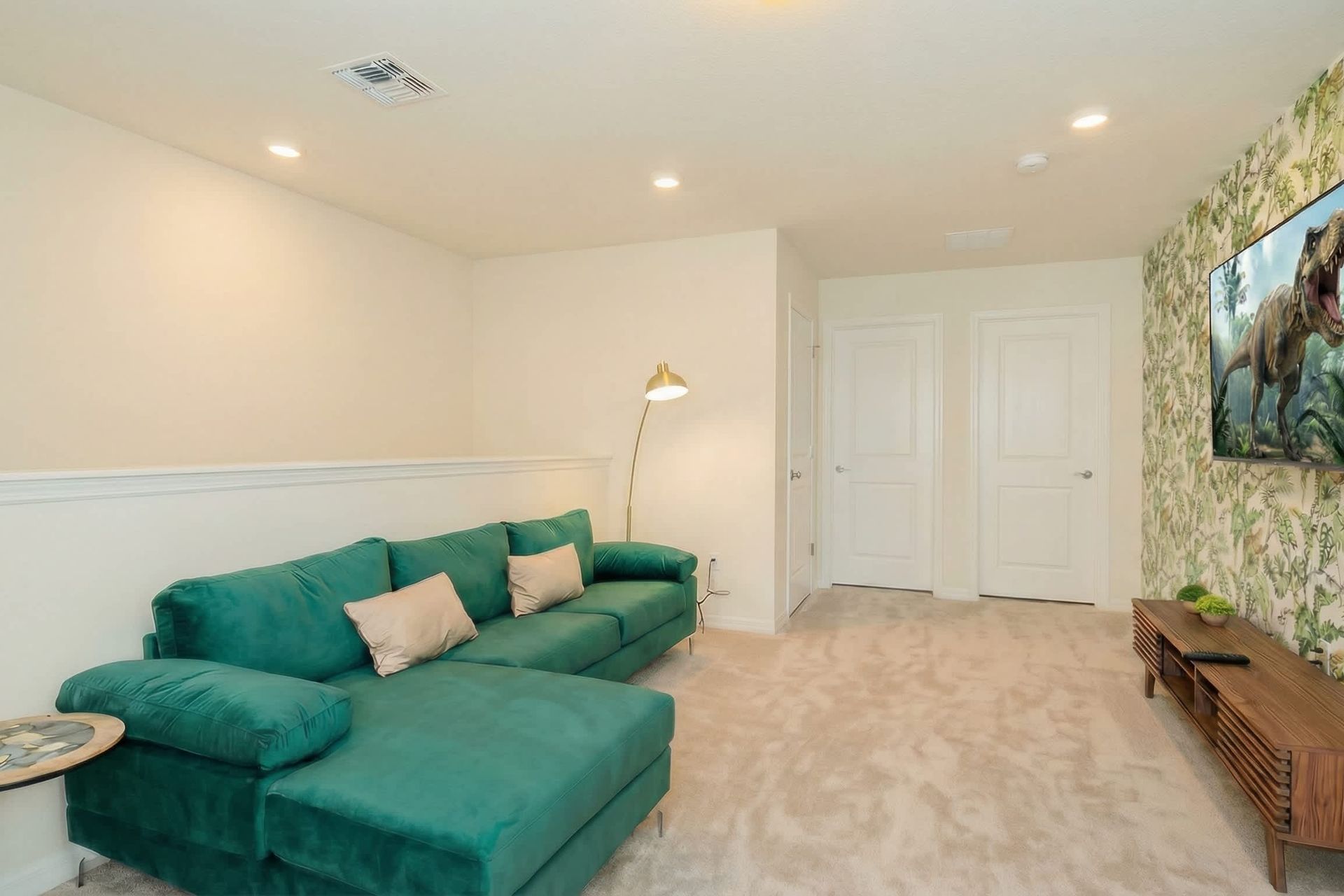 Tropical-themed loft with plush sectional and big-screen TV for movie nights.