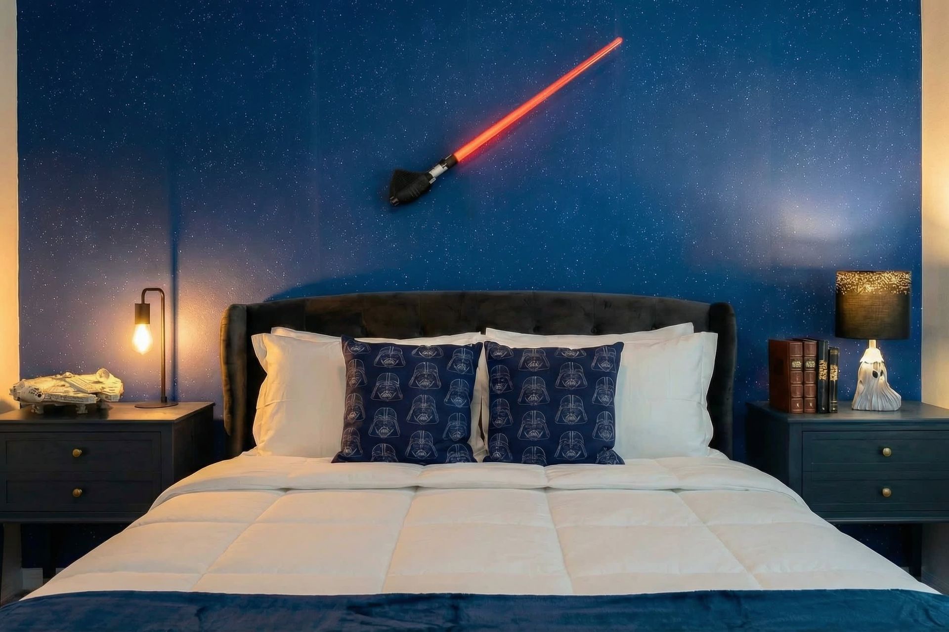 Galactic-themed bedroom with starry wall, cozy bedding, and fun space decor.