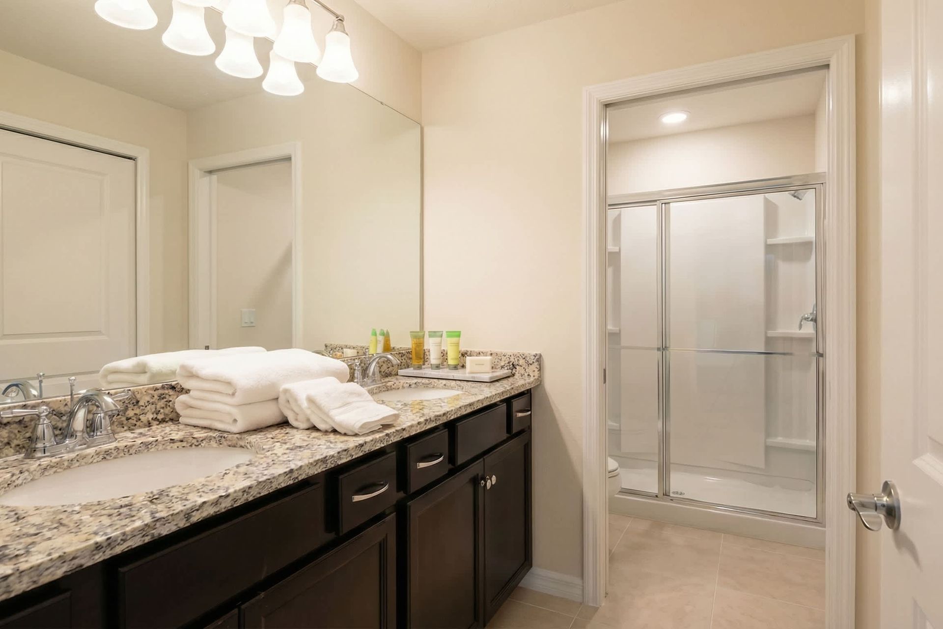 Spacious bathroom with double sinks, granite countertops, and walk-in shower.