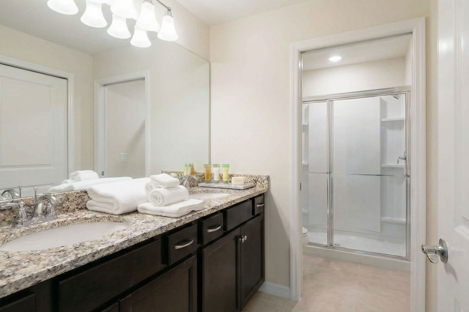 Spacious bathroom with double sinks, granite countertops, and walk-in shower.