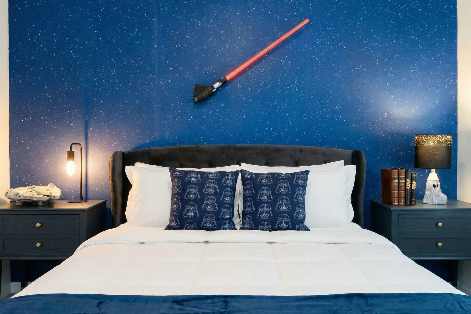 Galactic-themed bedroom with starry wall, cozy bedding, and fun space decor.