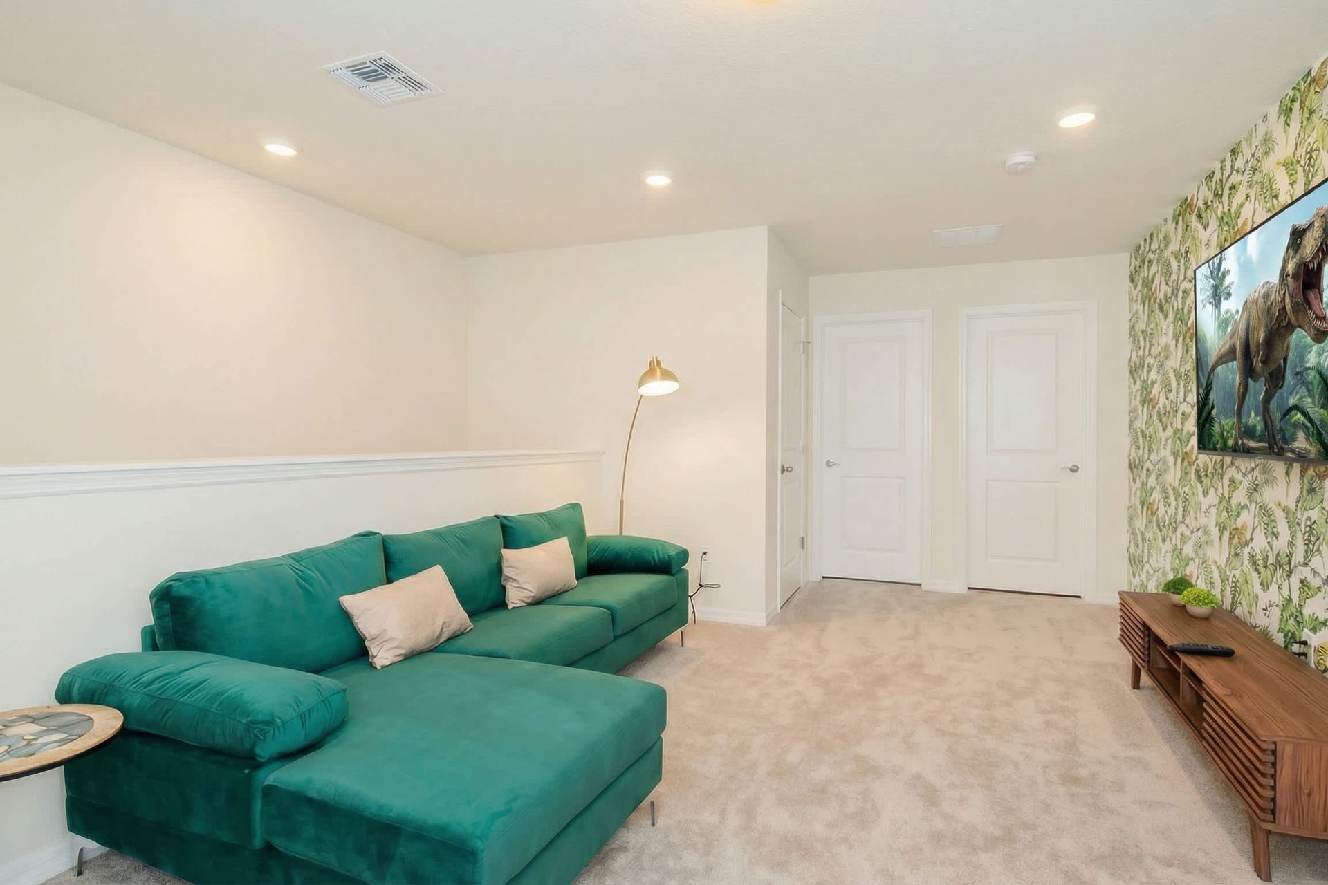 Tropical-themed loft with plush sectional and big-screen TV for movie nights.