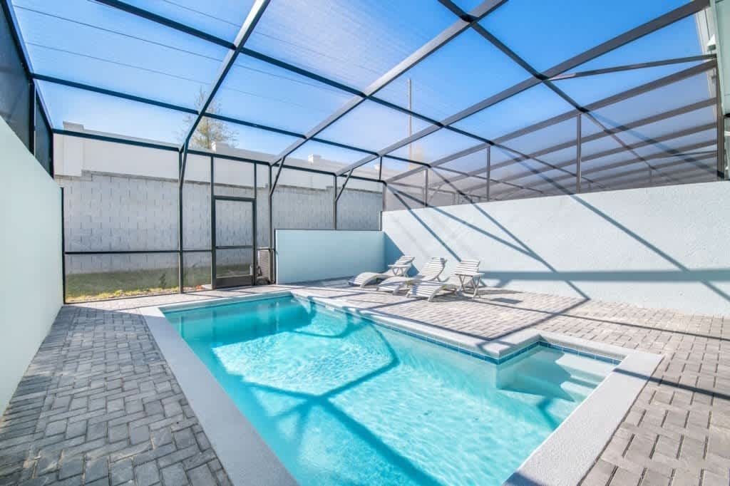 Relax in your private screened-in pool oasis with loungers and outdoor dining.