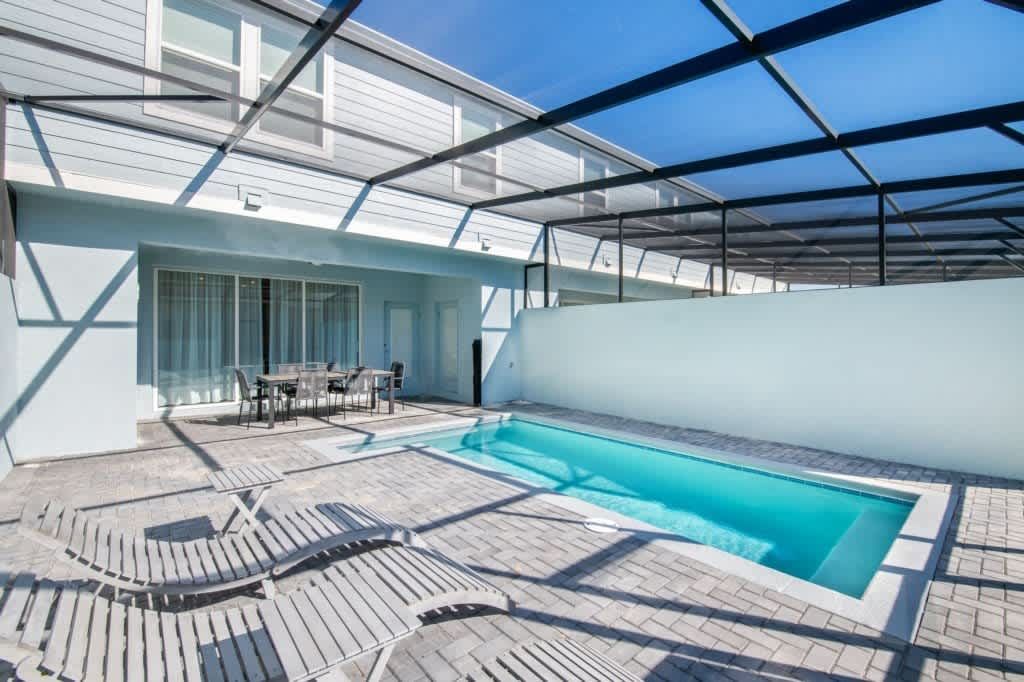 Relax in your private screened-in pool oasis with loungers and outdoor dining.