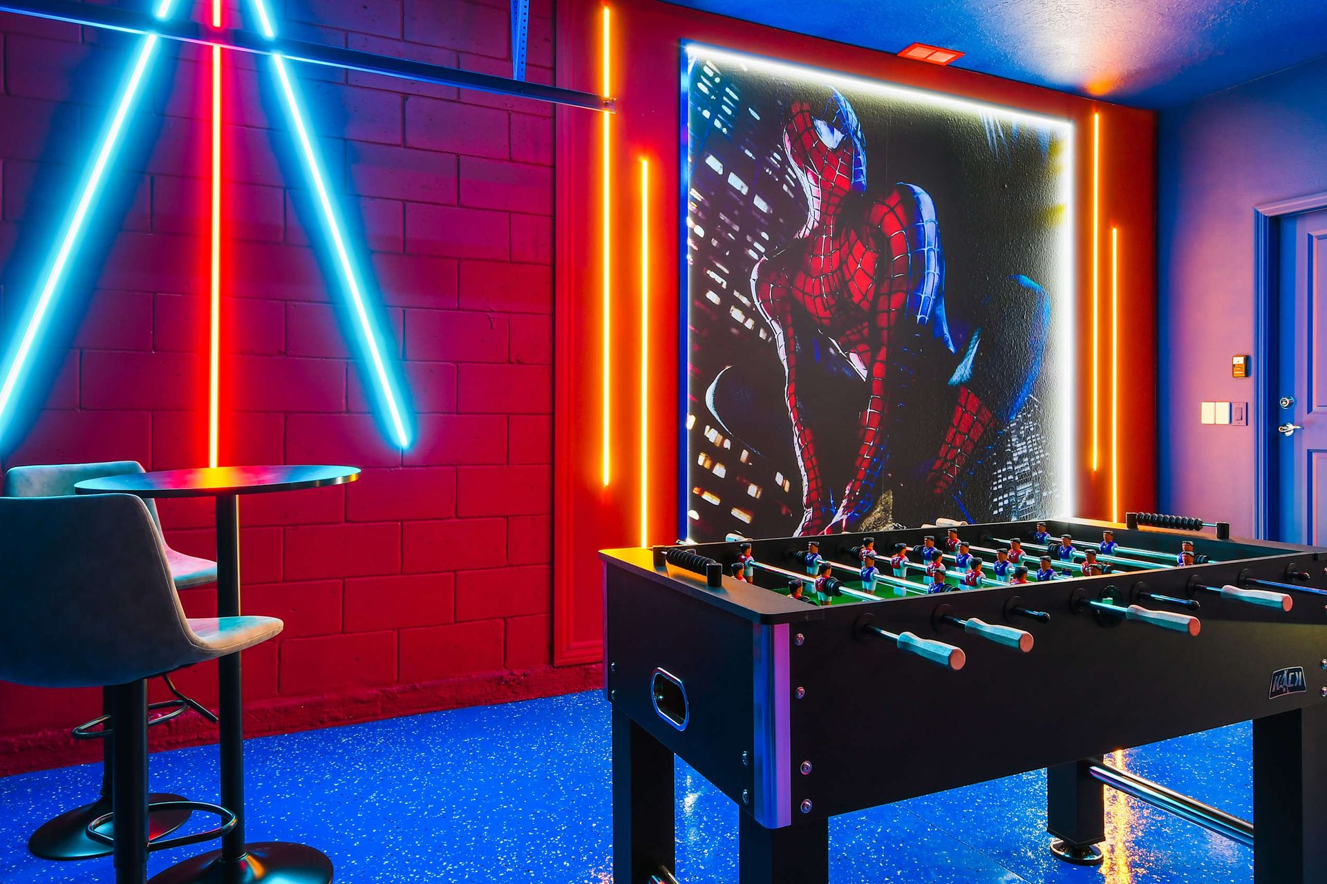 Action-packed superhero game room with neon lights, foosball, and bold wall art
