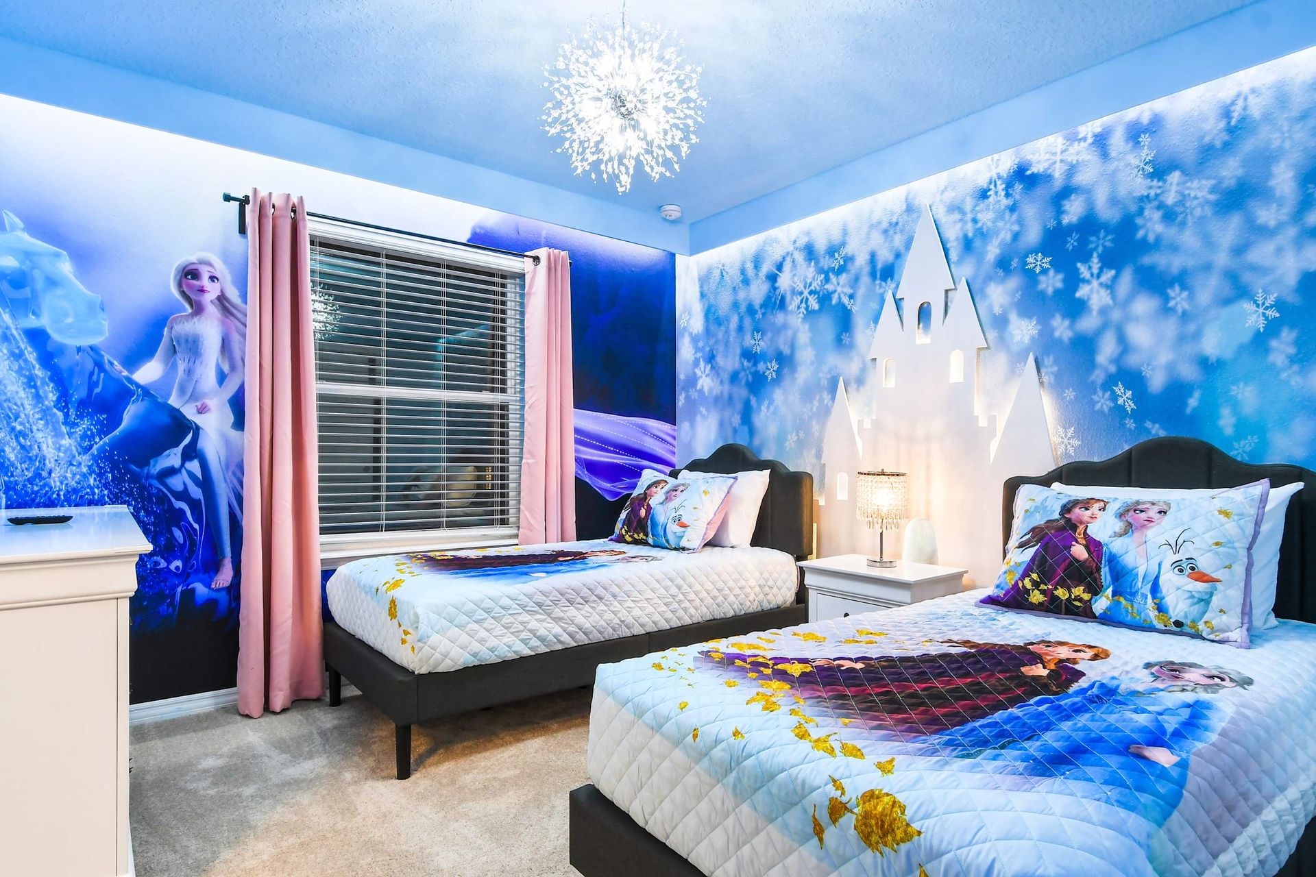 Magical Frozen-themed bedroom with twin beds, snowy murals, and sparkling lighting
