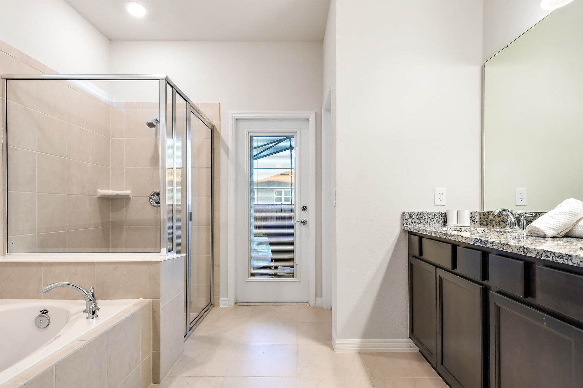 Spacious spa-like bathroom with soaking tub, glass shower, double granite vanity
