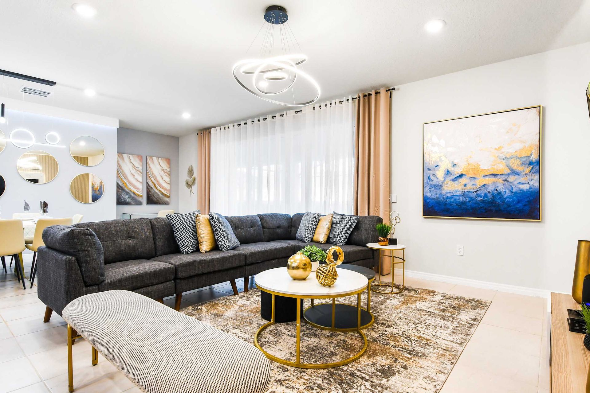 Stylish open living and dining area with modern art, luxe touches, and comfort
