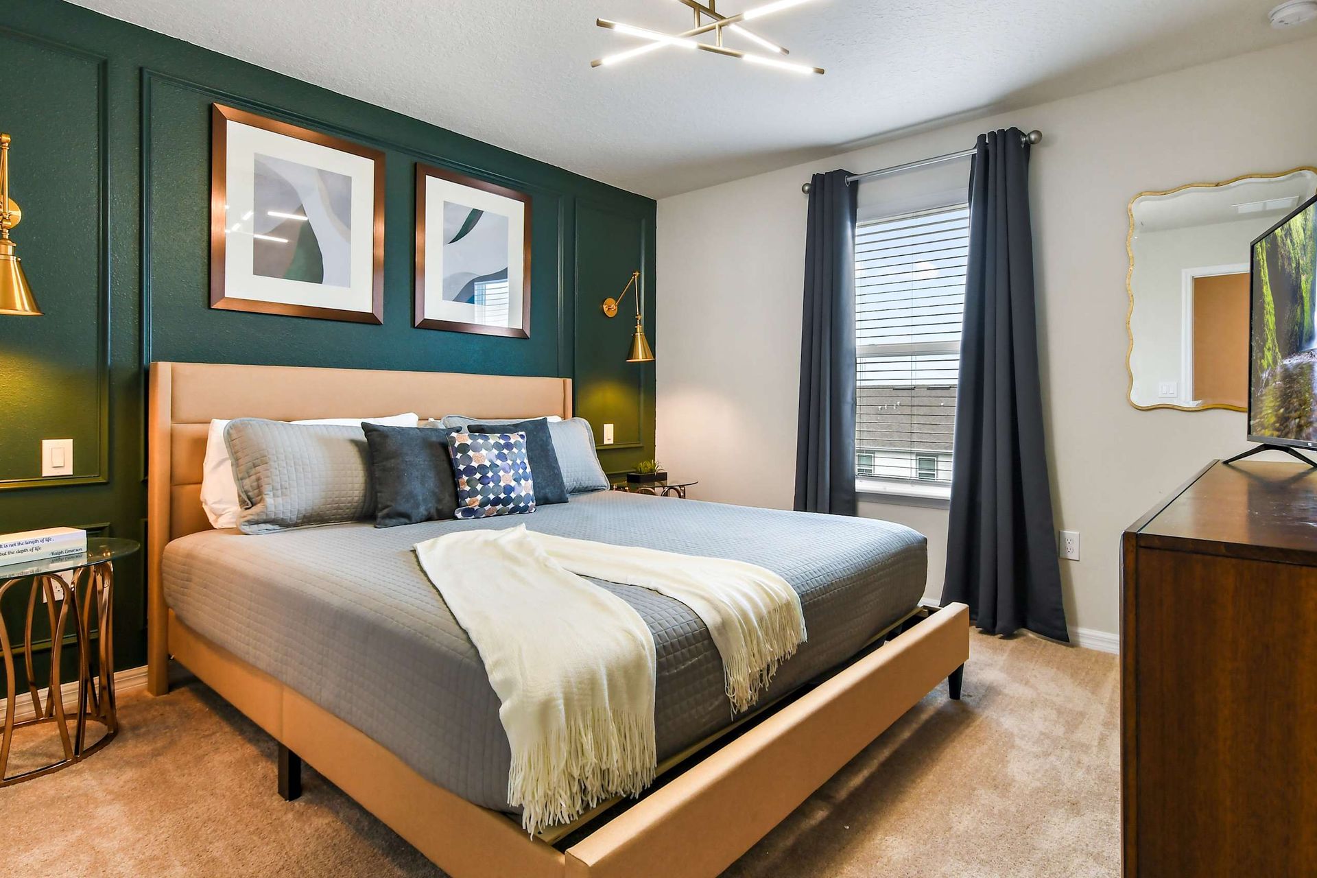 Modern cozy bedroom with elegant green accent wall, plush bedding, and smart TV!
