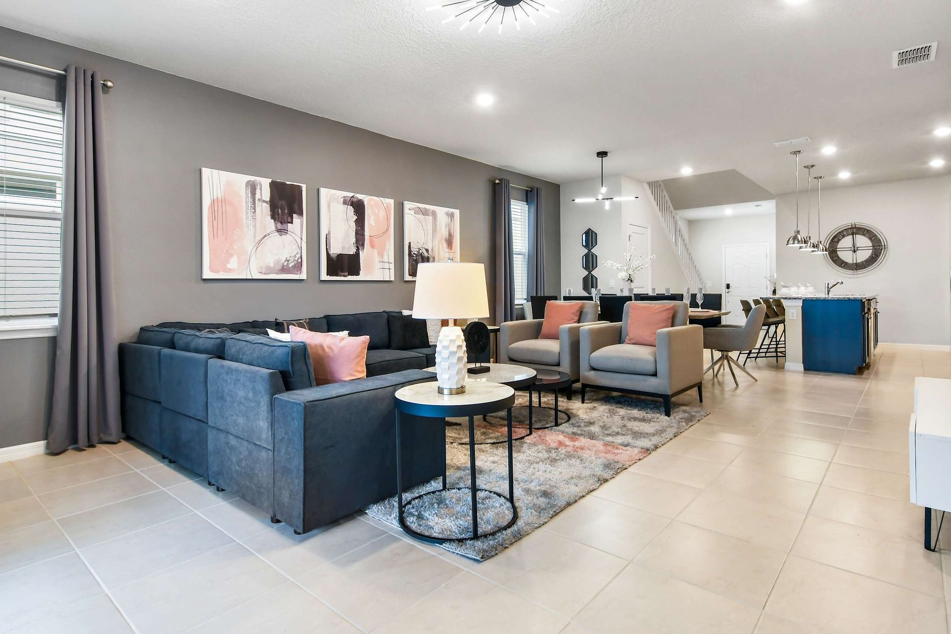 Spacious modern living area with comfy seating, stylish decor, and open kitchen!
