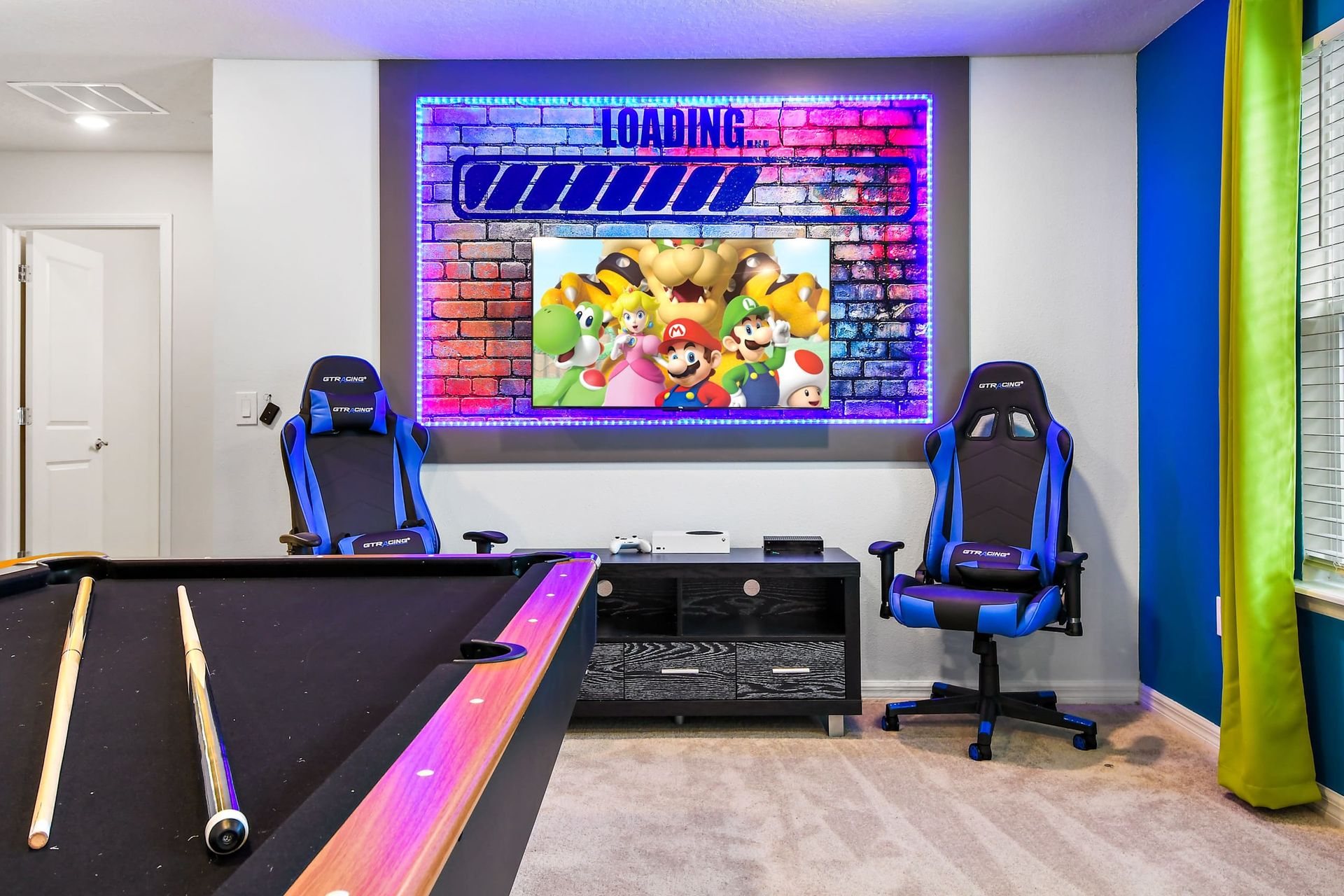 Vibrant Mario gamer’s paradise with LED lights, pool table, and pro gaming chairs!
