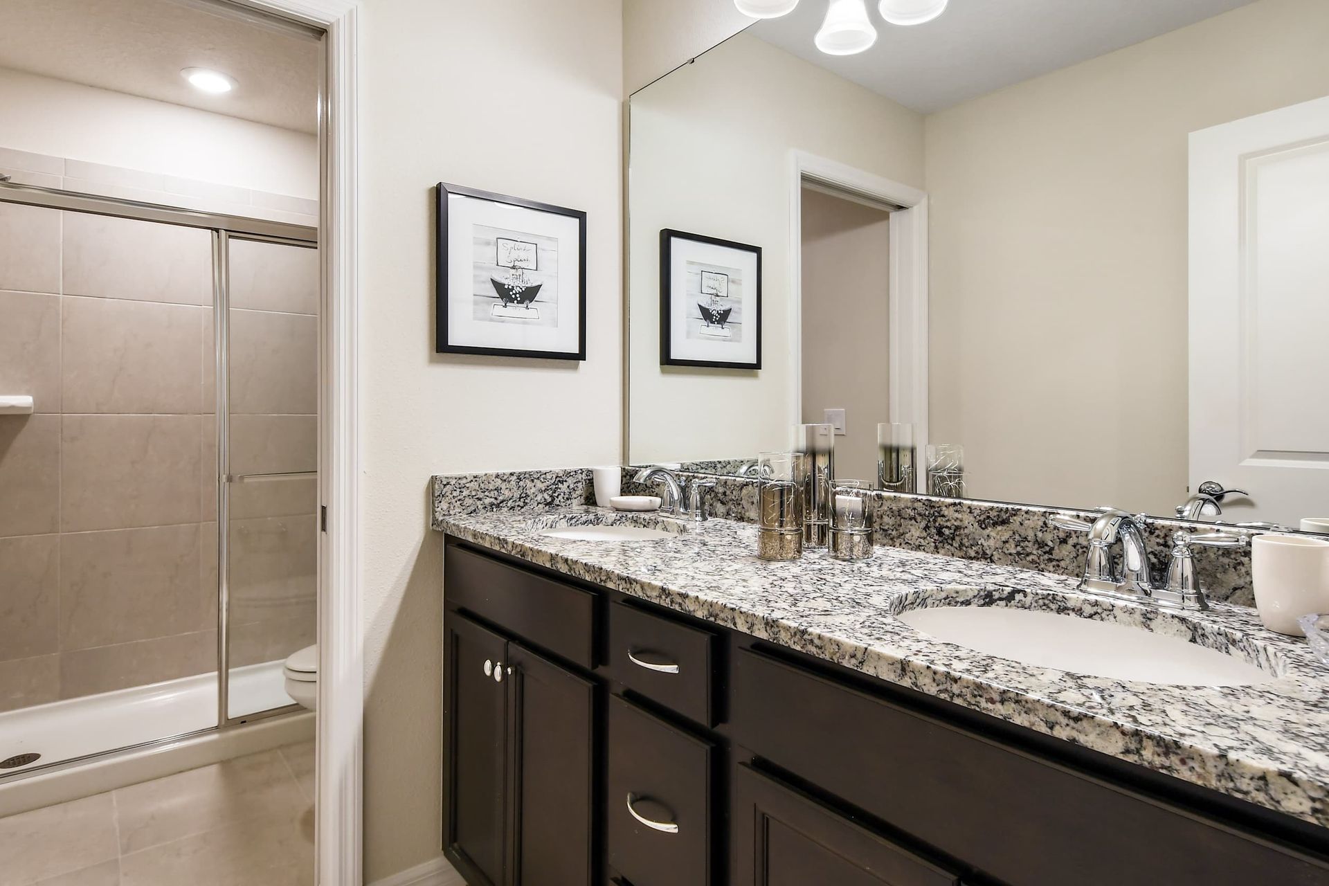 Stylish bathroom with granite double sinks, large shower, and sleek modern design
