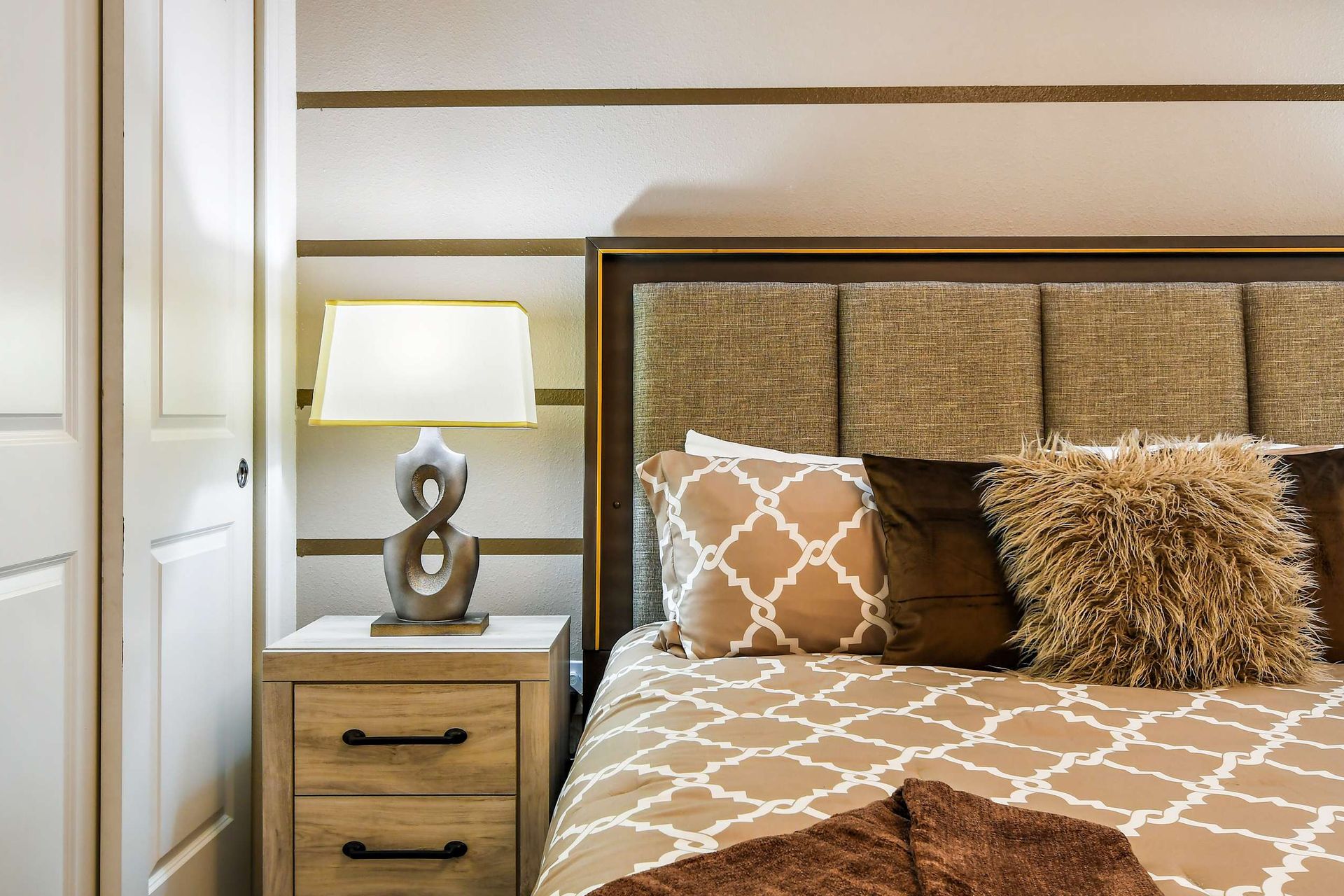 Warm modern bedroom with stylish decor, cozy bedding, and elegant ambient lighting!
