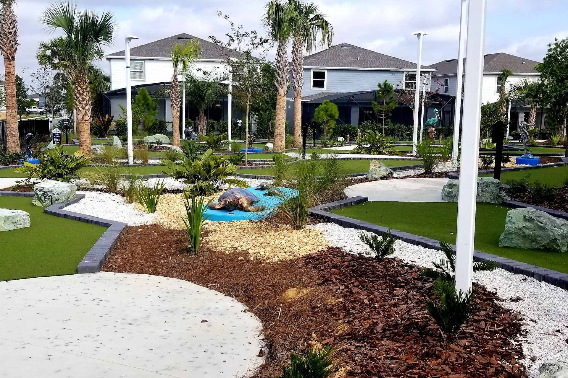 Scenic mini golf course with palm trees, tropical landscaping, and fun obstacles
