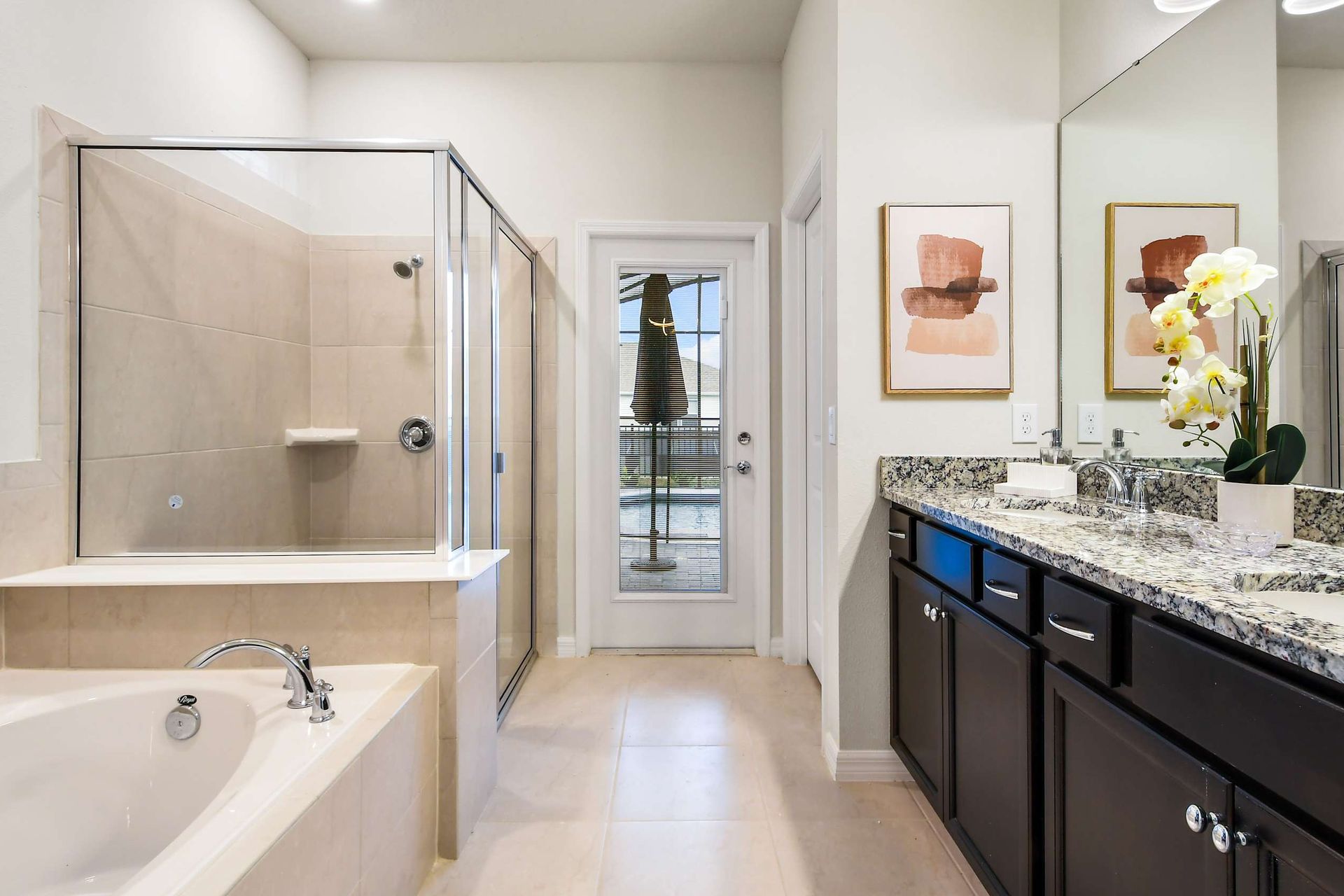 Elegant bathroom with double vanity, soaking tub, walk-in shower and patio access

