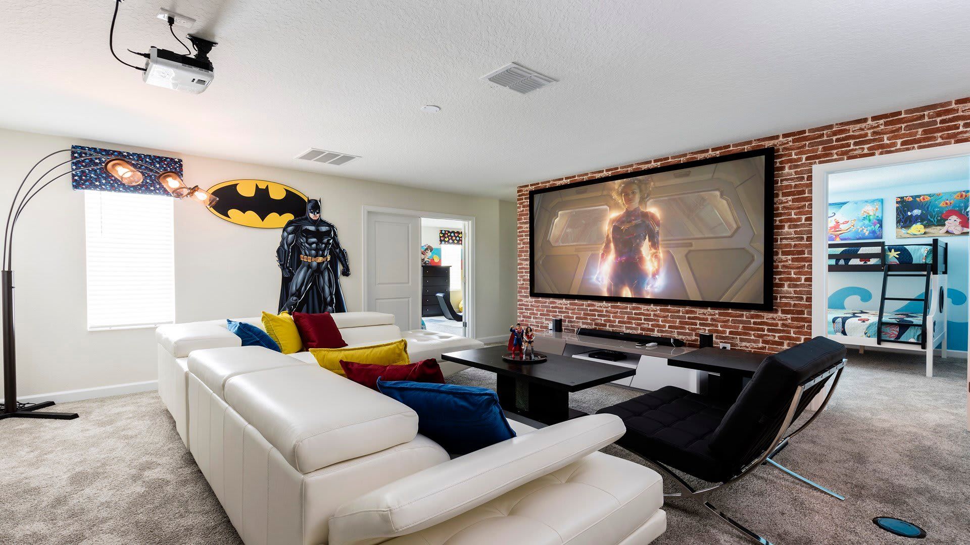 Superhero-themed home theater with comfy seating and projector.