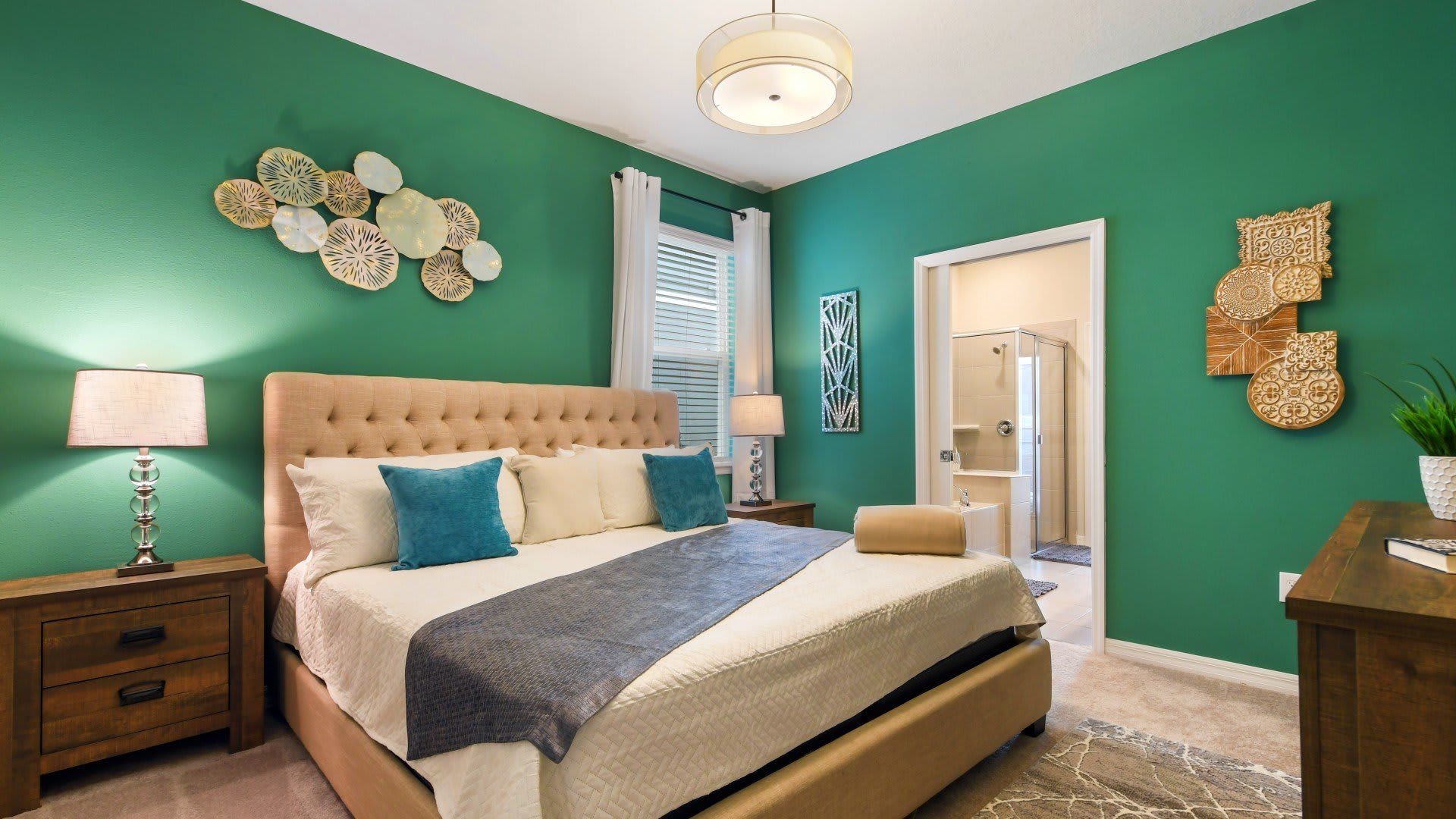 Elegant bedroom with emerald green walls, plush king bed, and private ensuite bath.