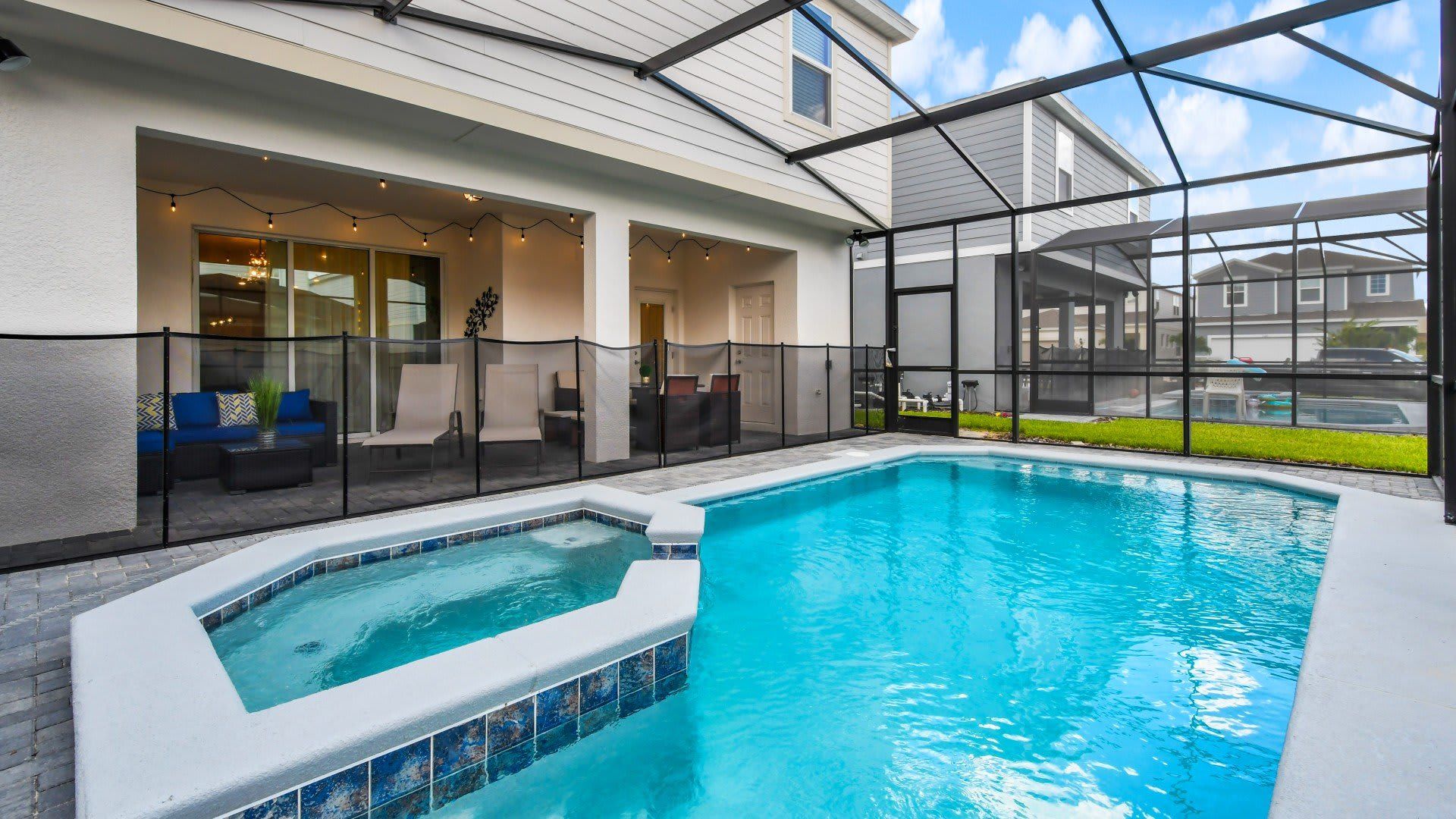 Screened-in private pool and spa with lounge seating and covered patio retreat.