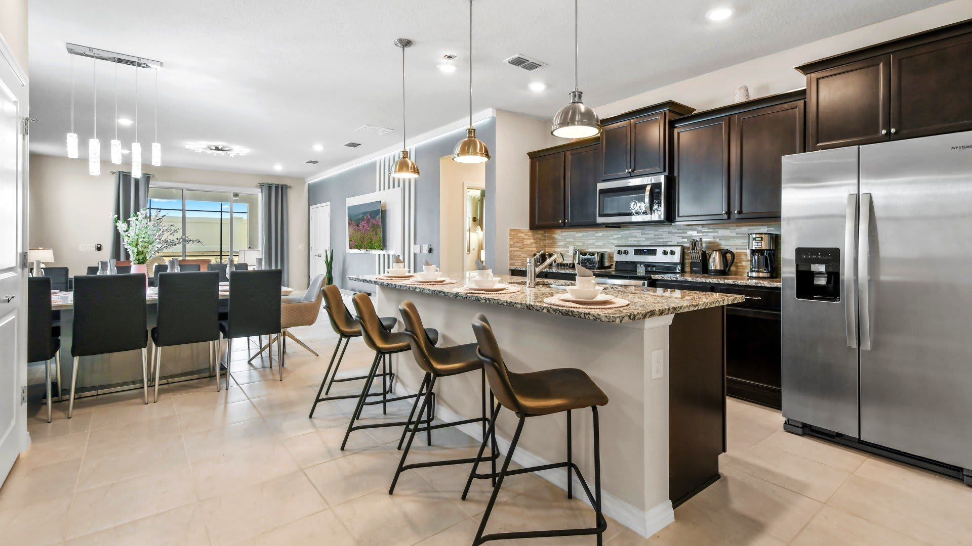 Spacious modern kitchen with granite island and seating, perfect for entertaining.