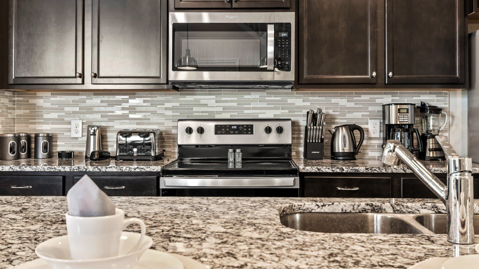 Fully stocked kitchen with stainless steel appliances and granite countertops.