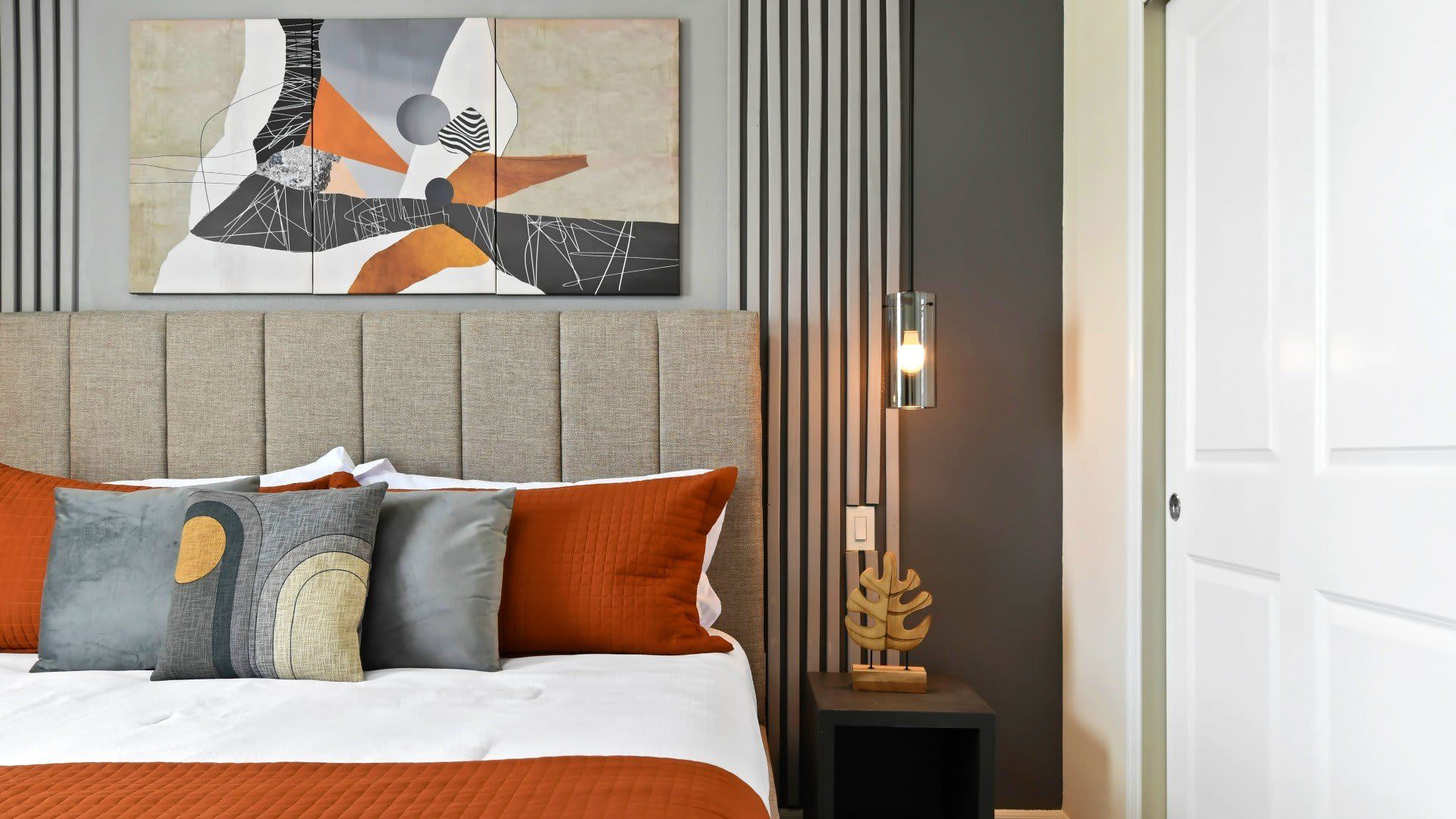 Stylish king bedroom with modern decor, cozy linens, and designer lighting.