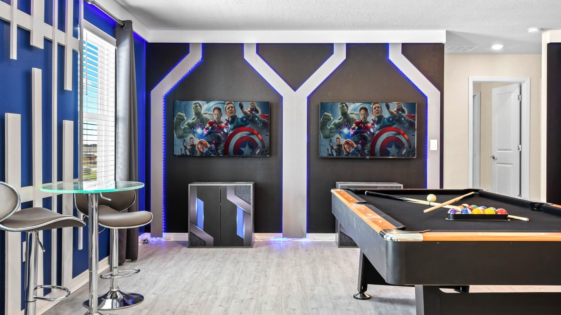 Epic game room with Marvel murals, pool table, and dual screens for nonstop fun.