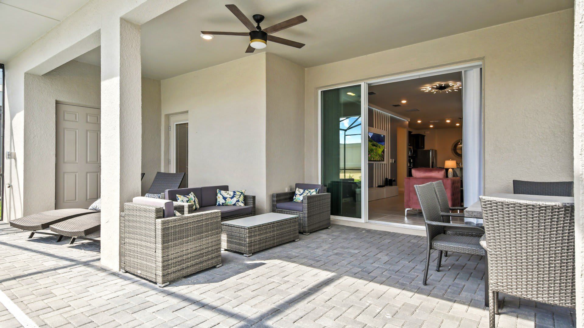 Relax in style with shaded outdoor seating, ceiling fan, and poolside access.