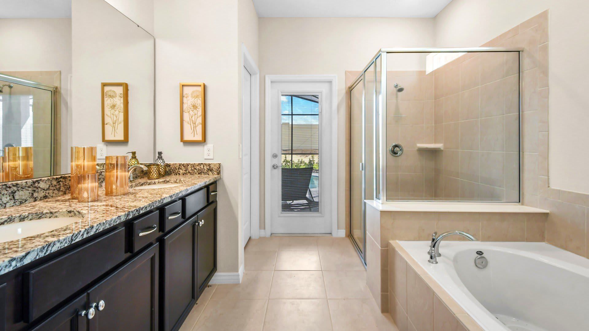 Elegant ensuite with double sinks, walk-in shower, soaking tub, and pool access.