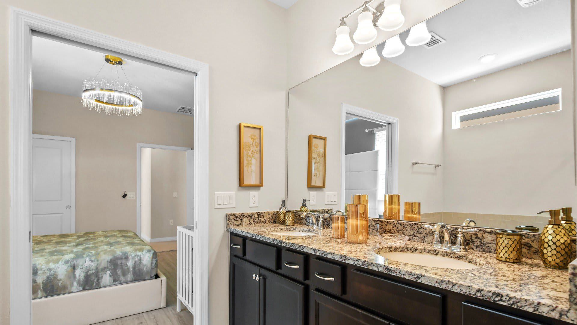Spacious primary bath with granite double vanity and elegant gold accents throughout.