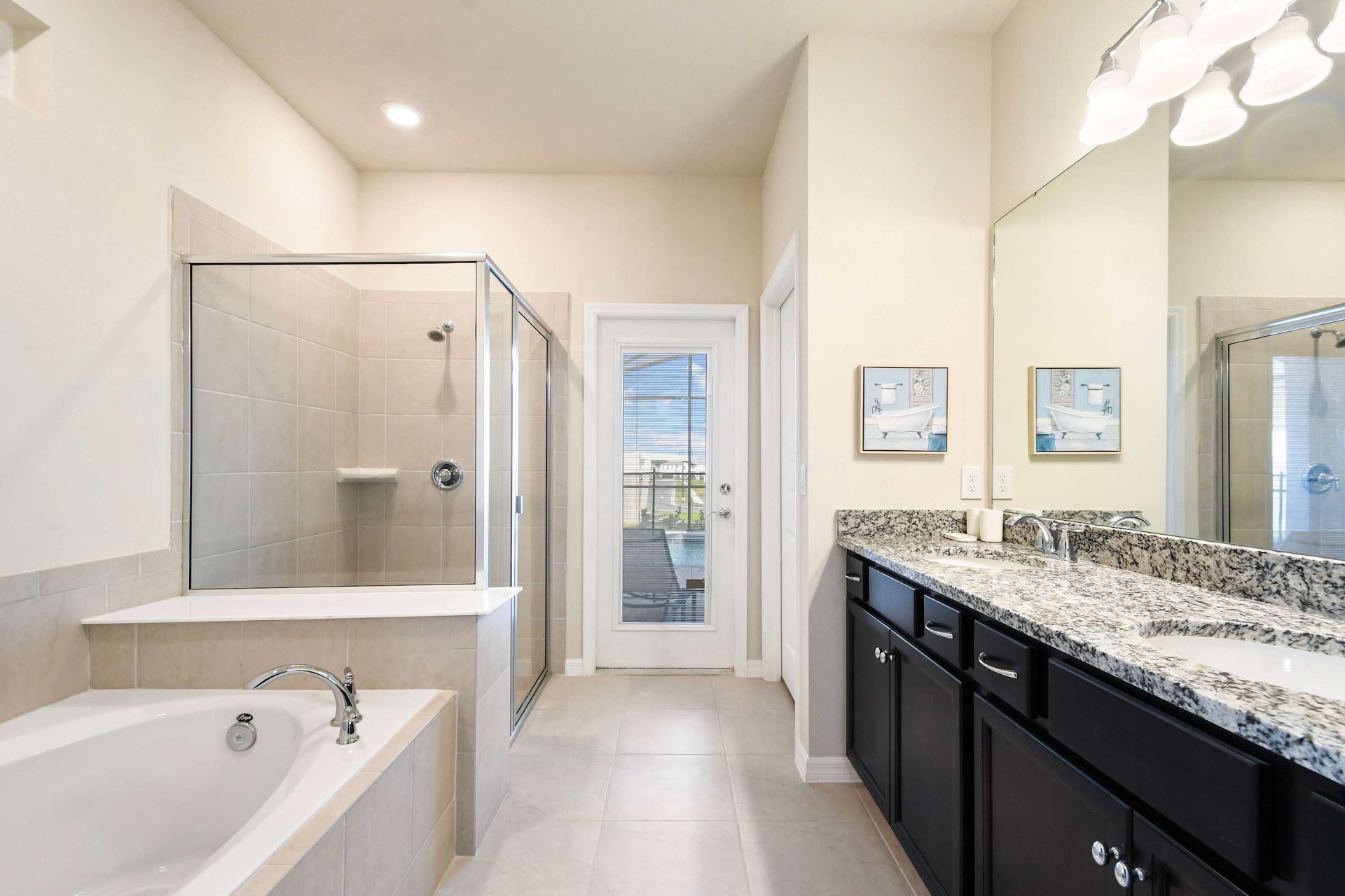 Elegant ensuite with soaking tub, glass shower, and private poolside access.