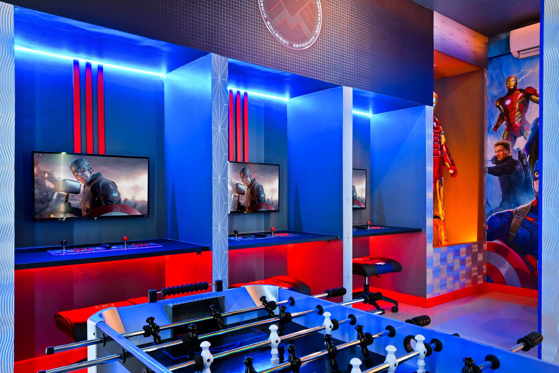 Epic Marvel-themed game room with arcade consoles and foosball action station.