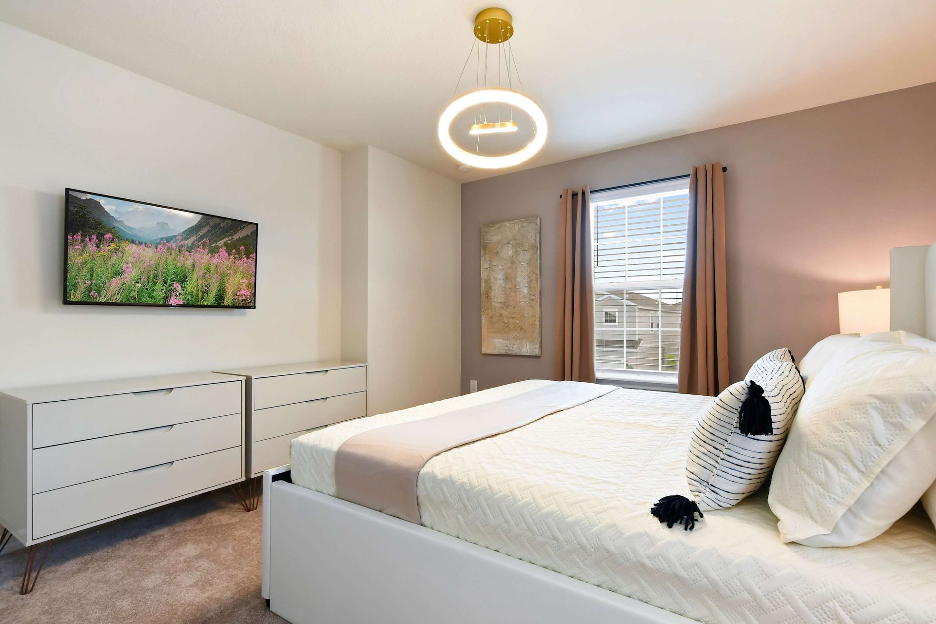 Modern king bedroom with cozy elegance, smart TV, and calming neutral tones.