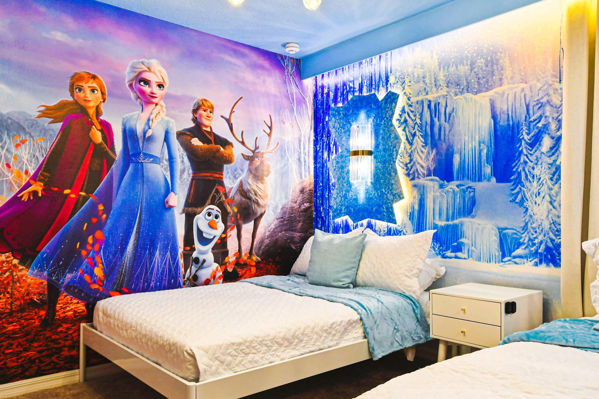 Whimsical Frozen-themed bedroom with icy decor, soft lighting, and cozy twin beds.