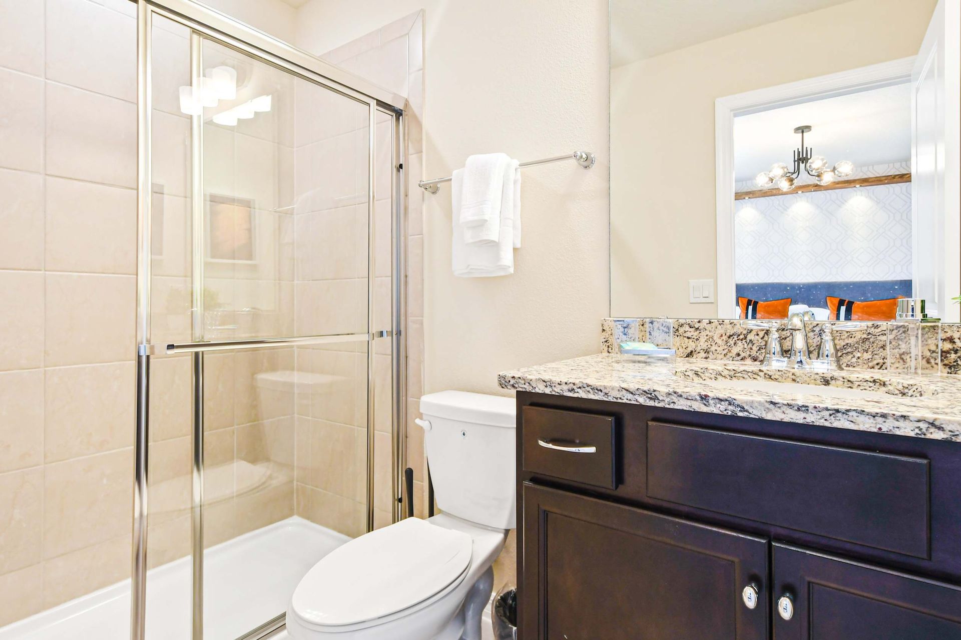 Bright bathroom with granite vanity, glass shower, and fun Minion-themed decor
