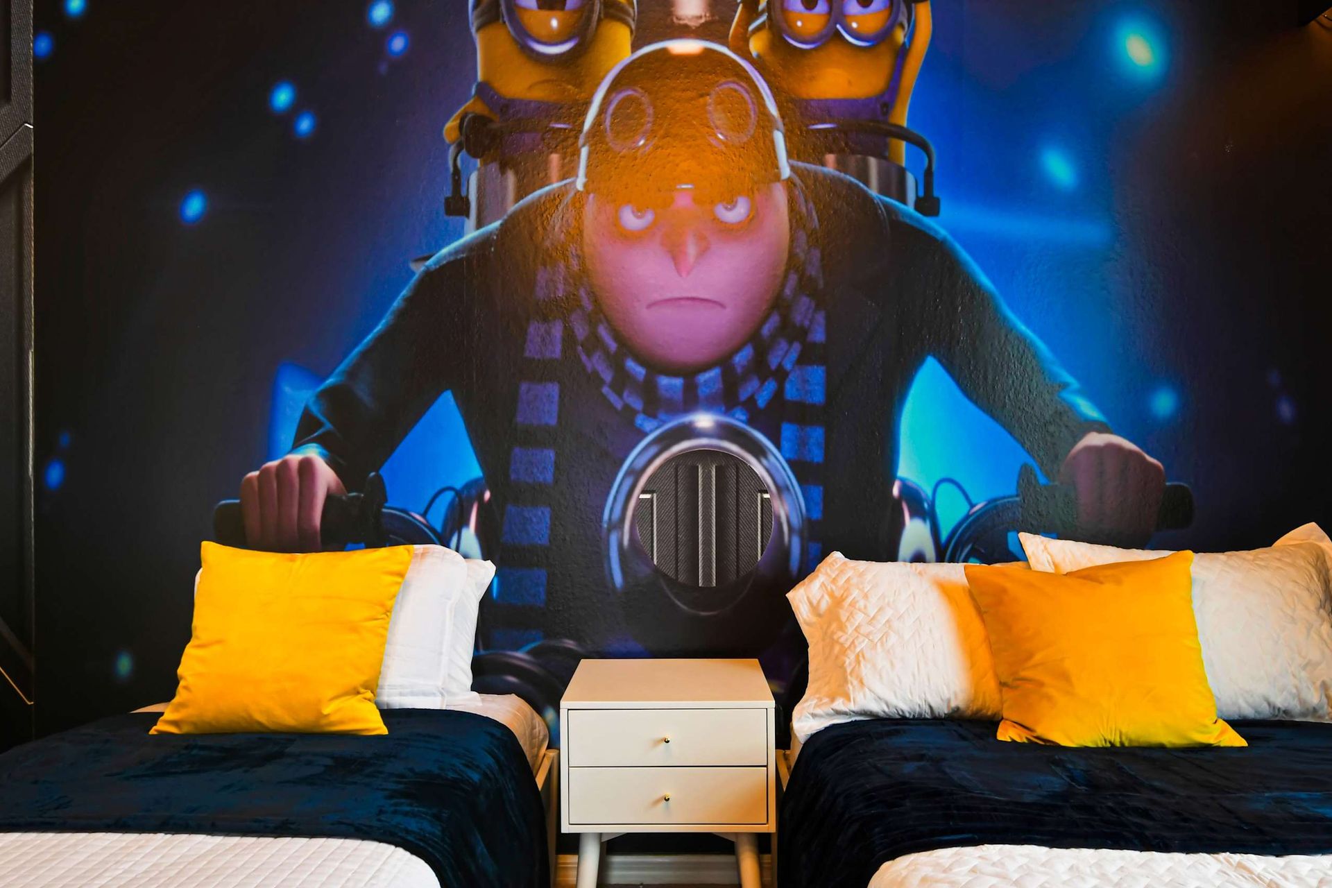 Fun Minion-themed room with twin beds, vibrant decor, and an immersive design.