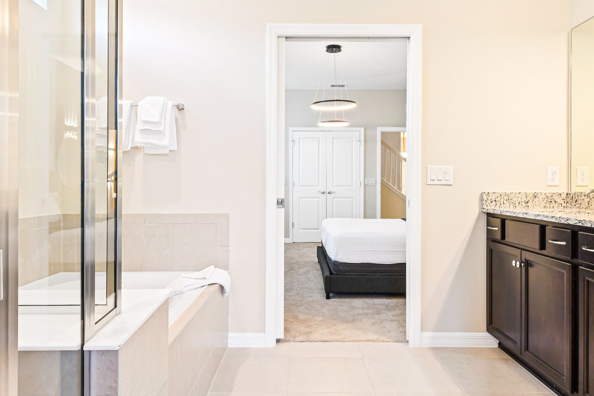 Elegant bathroom with double vanity, soaking tub, walk-in shower and patio access

