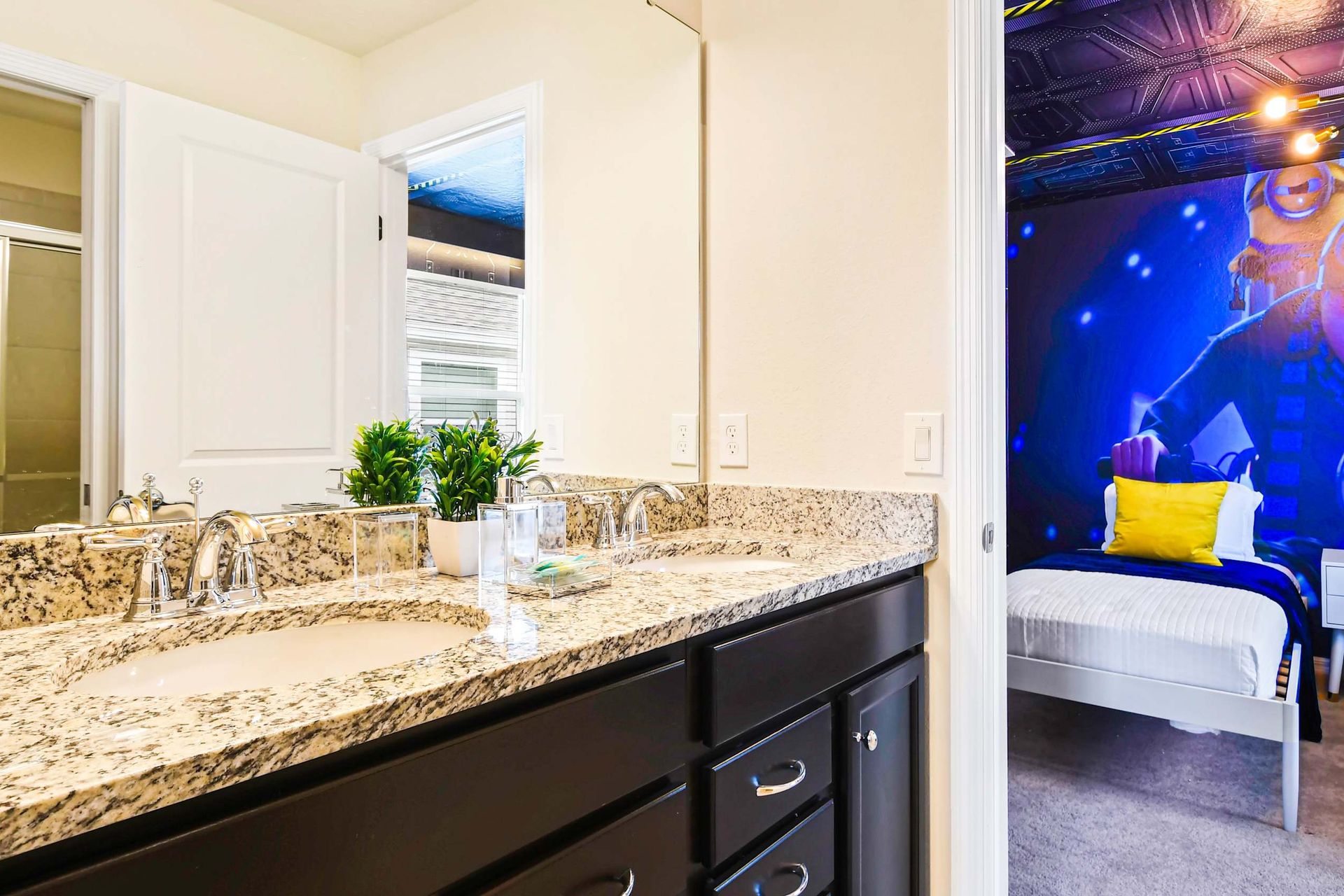 Stylish bathroom with granite double vanity, connects to fun Minion-themed bedroom
