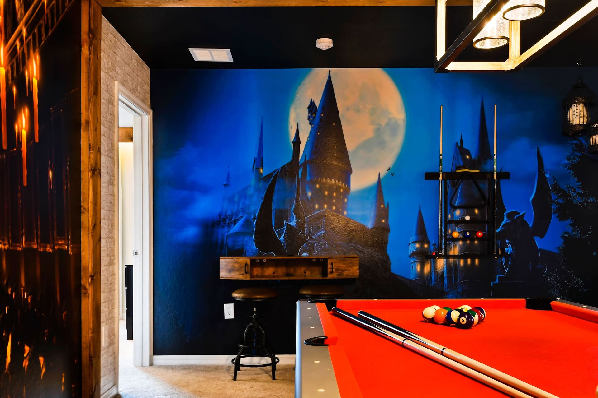 This Harry Potter-themed game room features magical decor, a ping pong table, and immersive wall art