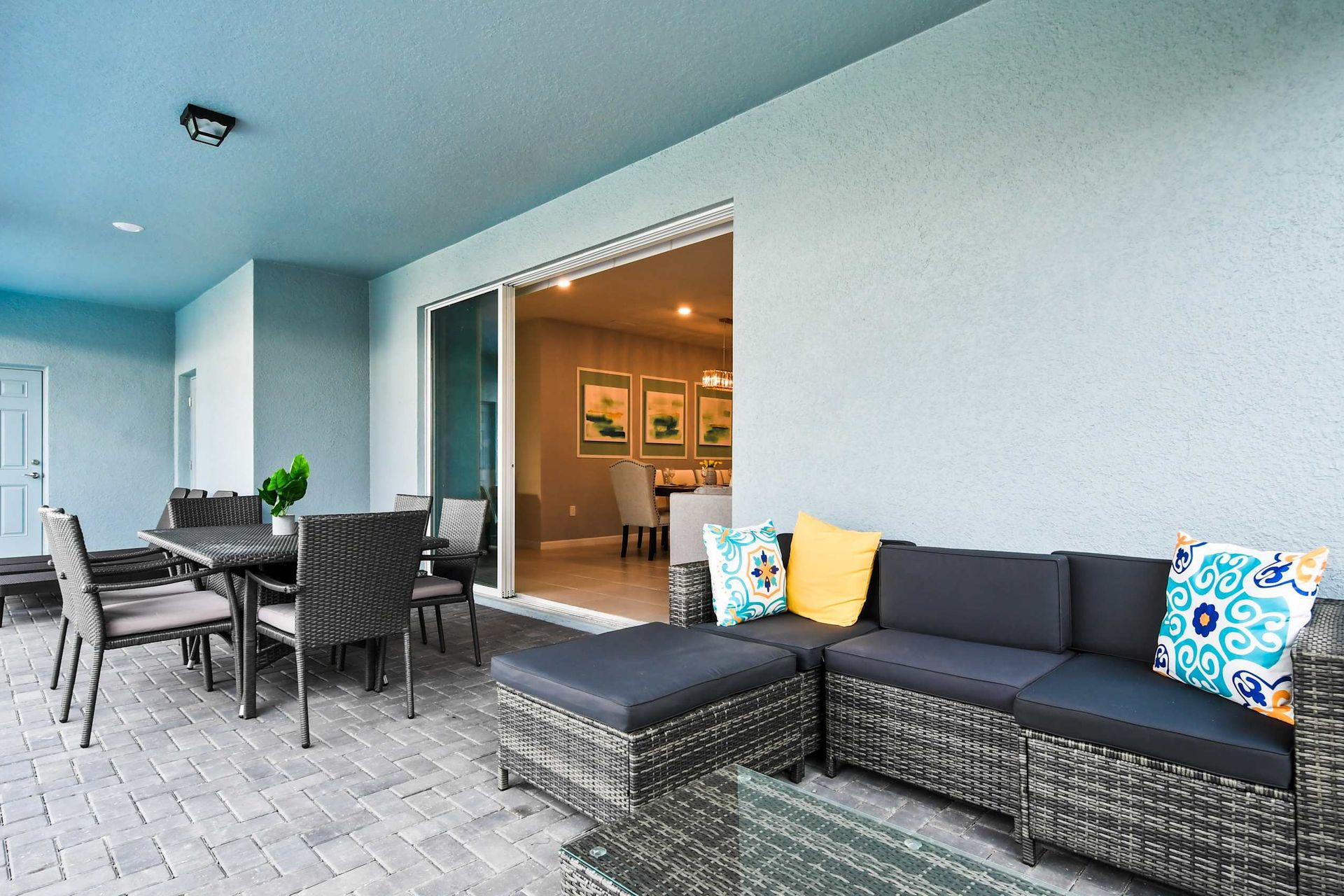 Spacious covered lanai with dining, lounge seating, and direct indoor access.