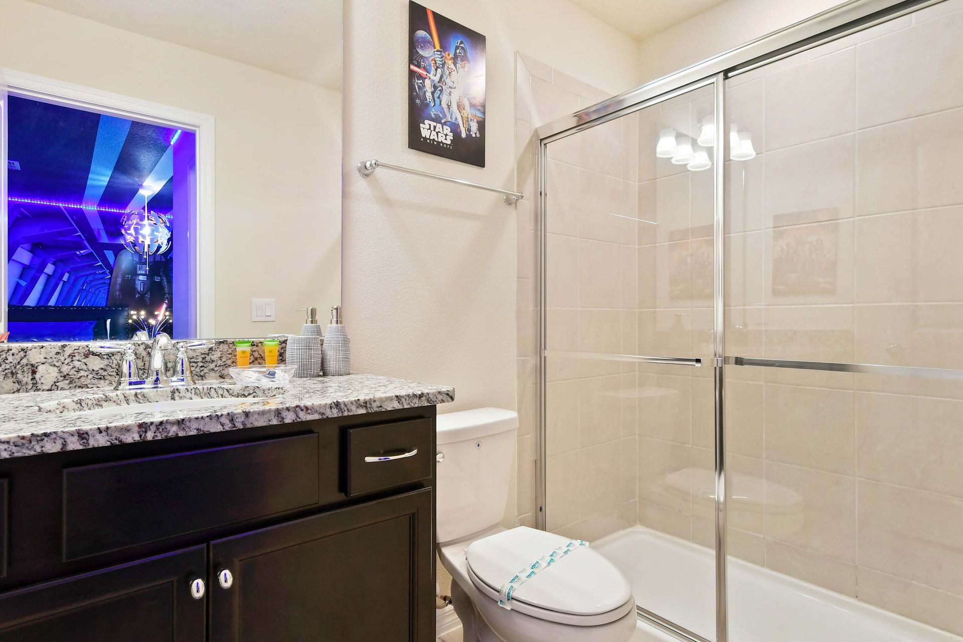 Granite-accented bathroom with walk-in shower and epic space-themed bedroom view.