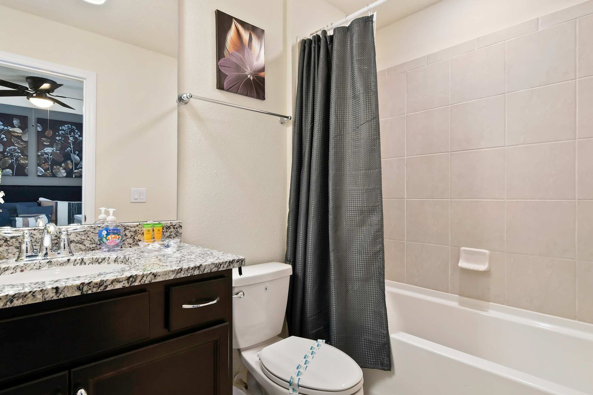 Chic bathroom with granite vanity, full tub, and a peek into a stylish bedroom.