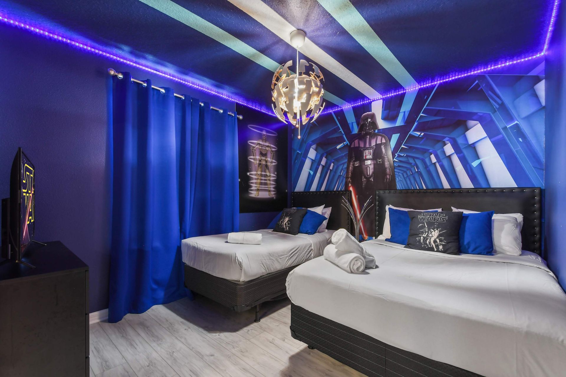 Galactic-themed room with immersive decor, LED lights, and twin beds.