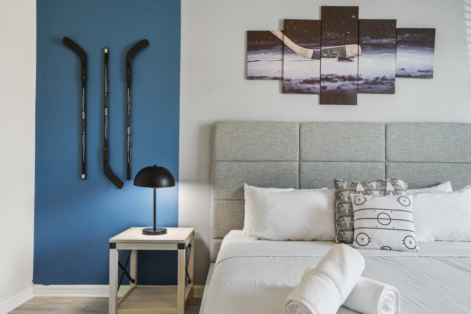 Hockey-themed bedroom with modern decor, cozy bedding, and natural light.